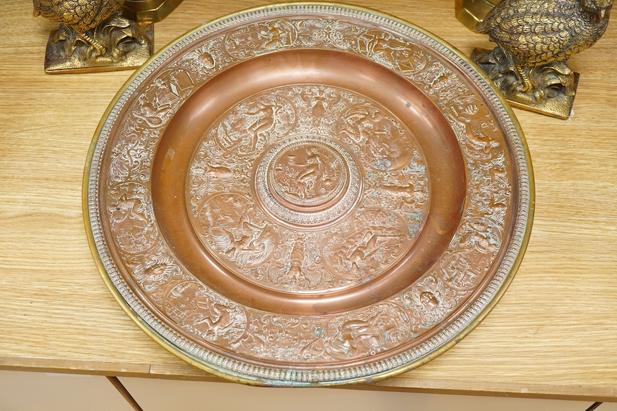 A group of copper and brassware to include candlesticks and an alms dish, 45cm in diameter